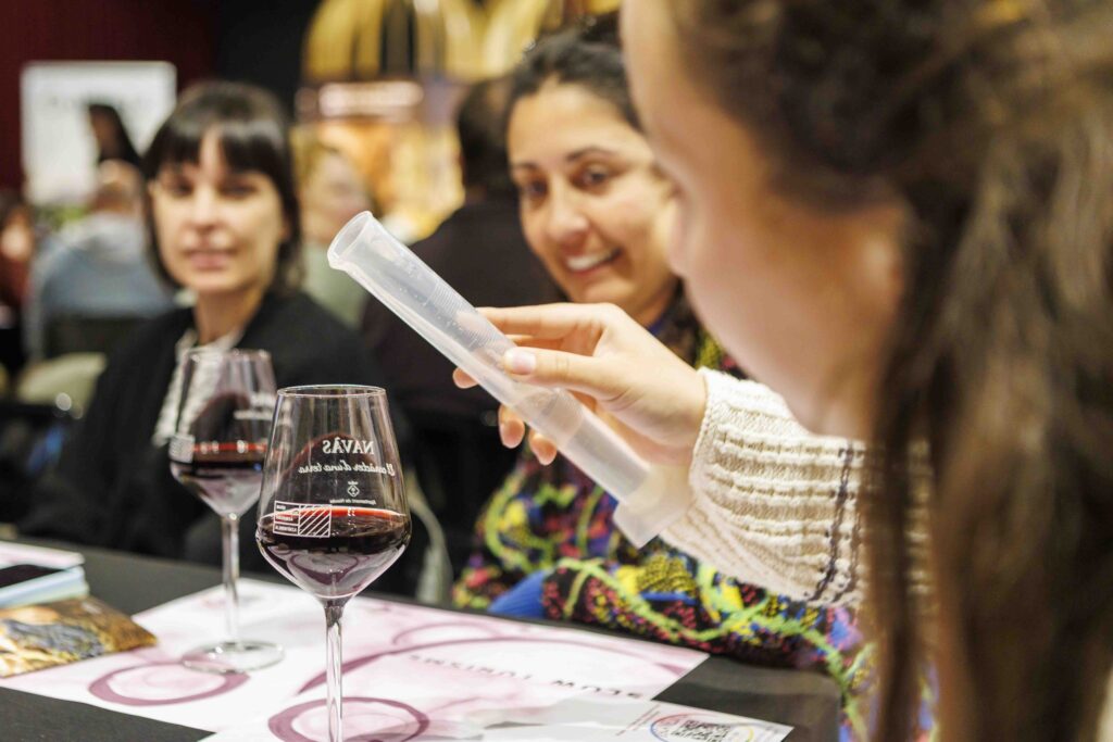 Persones participant en un taller per crear el seu vermut al Celler Collbaix, mesurant proporcions entre vins i herbes locals.
