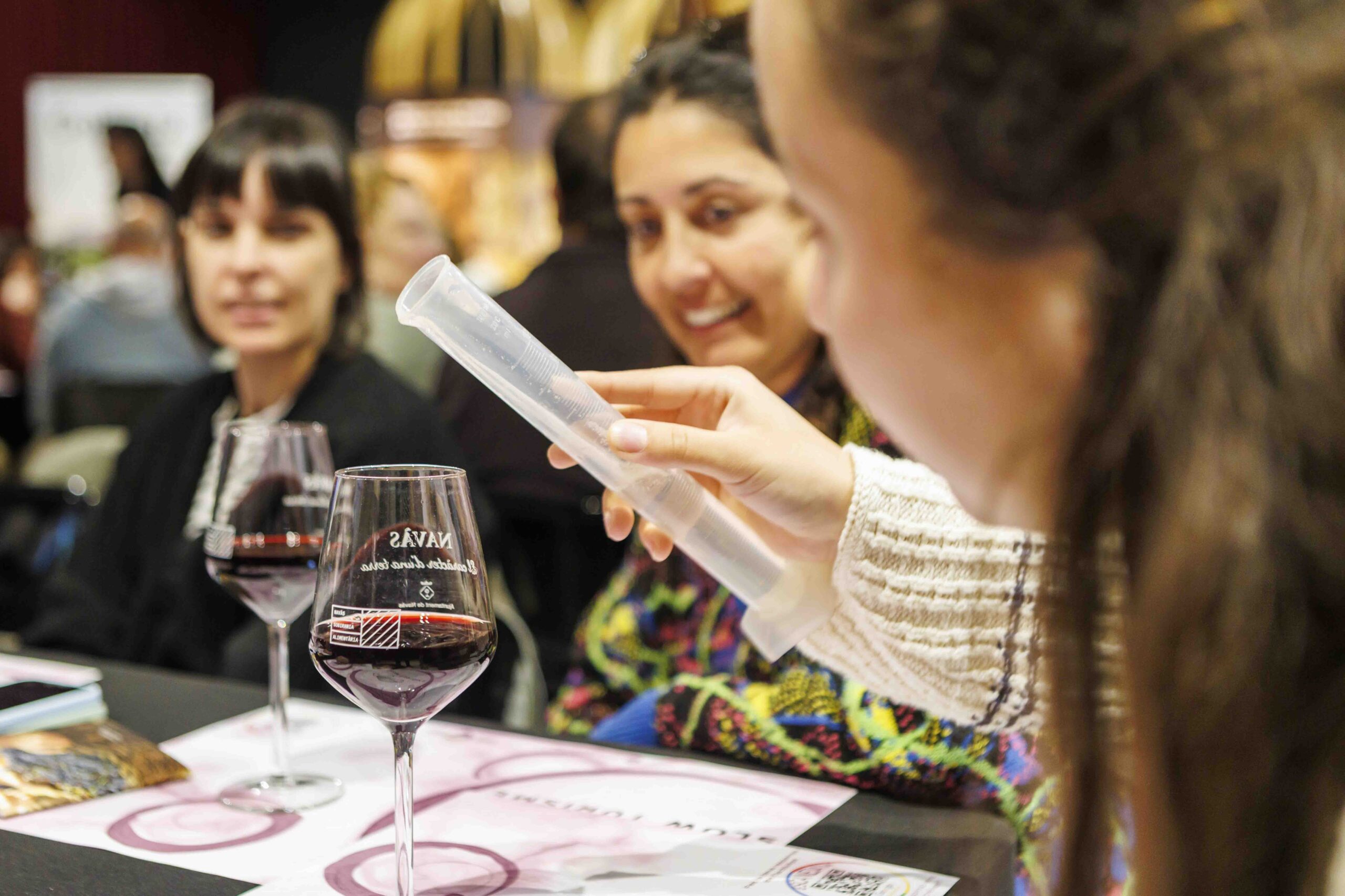 Persones participant en un taller per crear el seu vermut al Celler Collbaix, mesurant proporcions entre vins i herbes locals.