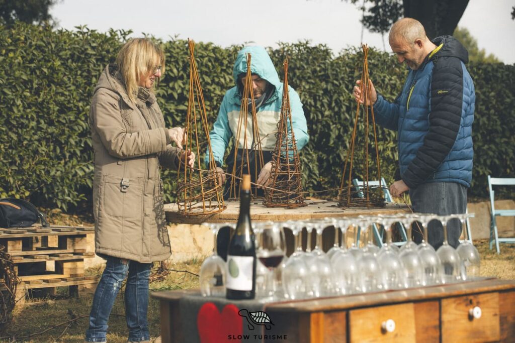 Taller Nadalenc amb sarments al Celler Fargas-Fargas, participants creant arbres de Nadal entre vinyes al Bages.