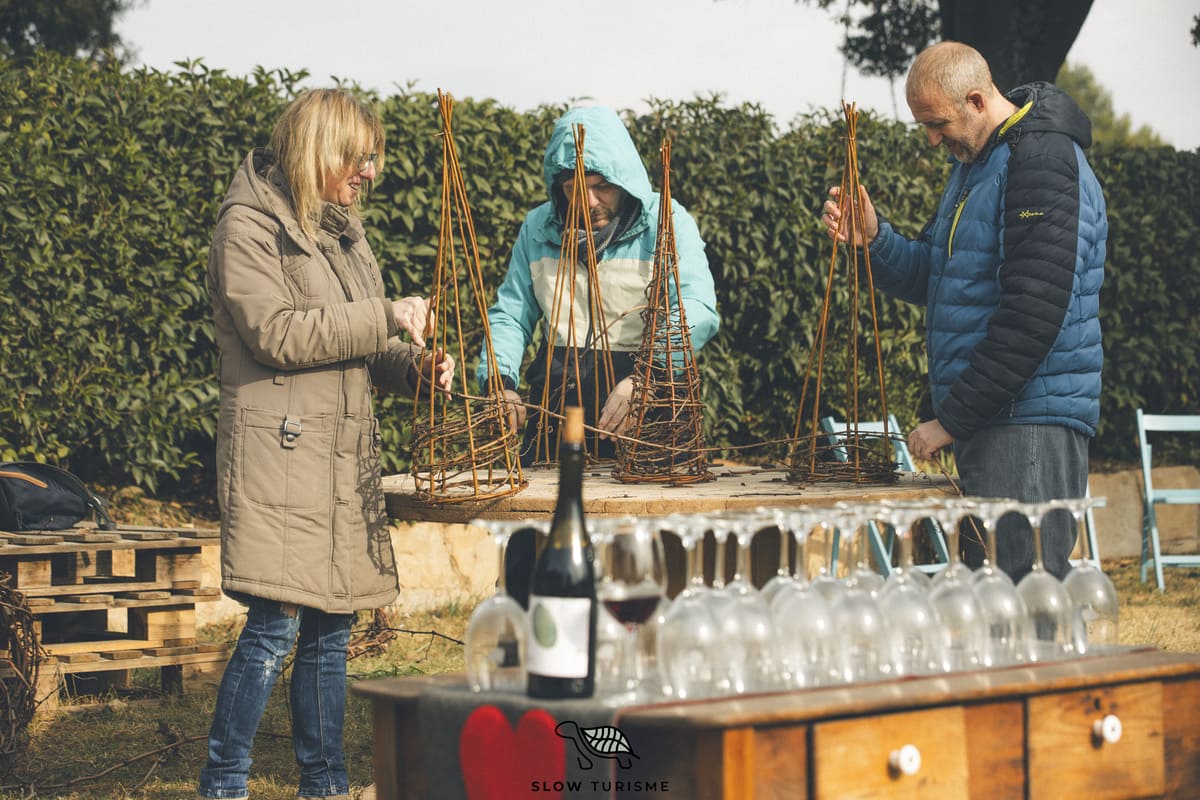 Taller Nadalenc amb sarments al Celler Fargas-Fargas, participants creant arbres de Nadal entre vinyes al Bages.