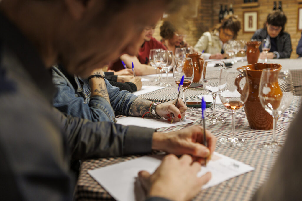 Participants escrivint durant una experiència de vins i grafologia al Collbaix Celler el Molí, DO Pla de Bages