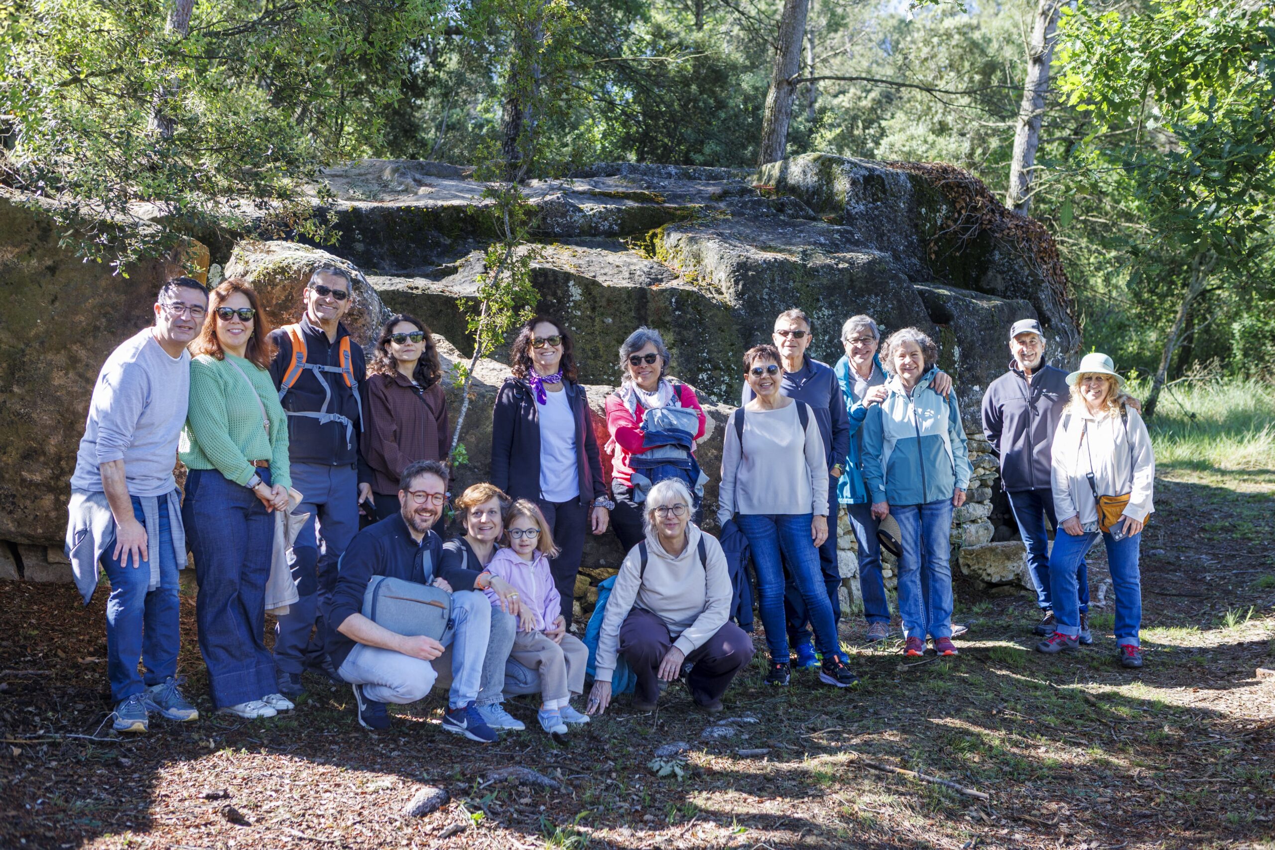 Participants davant una construcció de pedra seca descoberta durant la passejada entre vinyes
