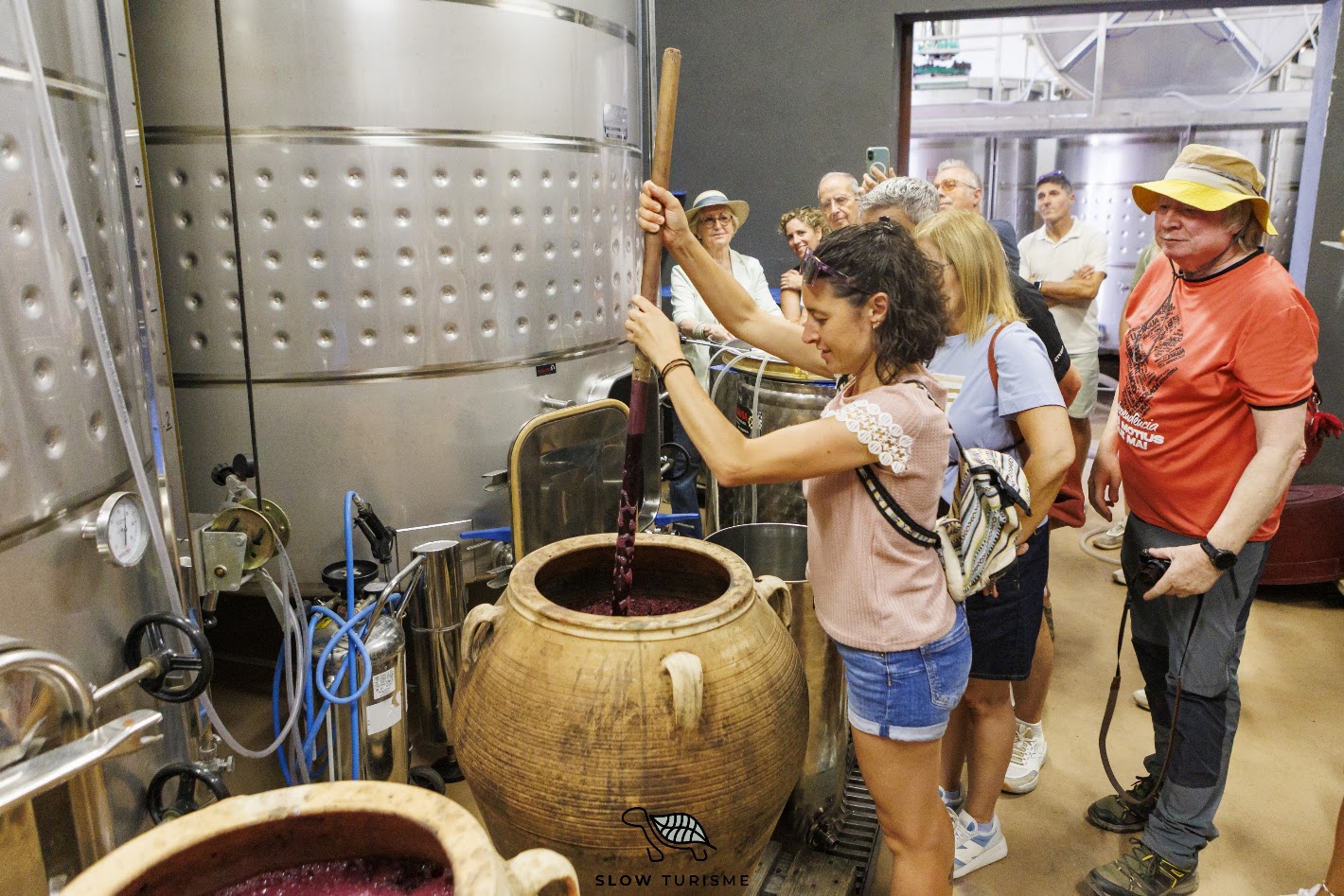 Participant fent pigeage en una àmfora de vi a Can Serra dels Exibis